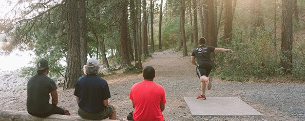 3 guys watching disc golfer Zach S.